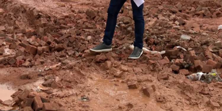 Sem solução pública, moradores gastam R$ 800 com pedras para tapar buracos em rua do bairro Rosa Linda